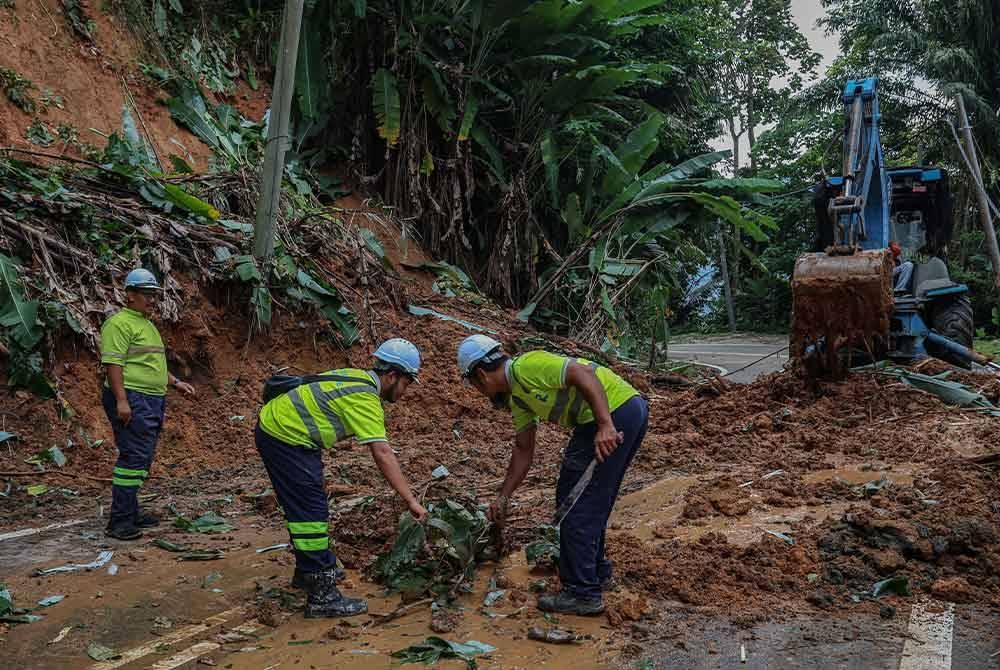 Kakitangan Roadcare melakukan kerja-kerja pembaikan berikutan keadaan Jalan Genting Sempah yang rosak akibat kejadian banjir puing yang berlaku malam semalam. - Foto Bernama