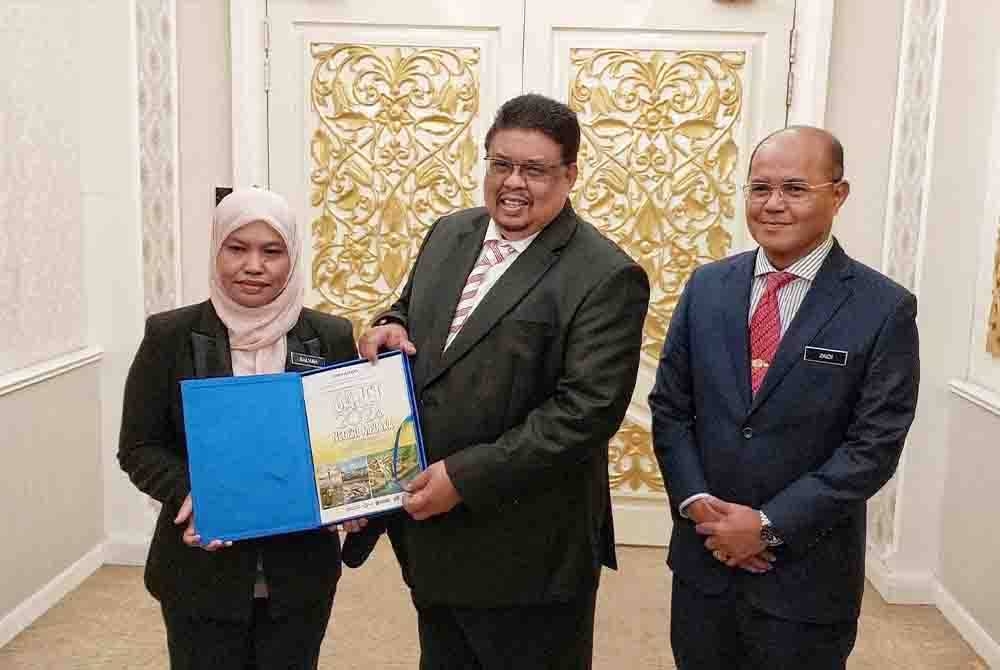 Ab Rauf (tengah) menunjukkan buku pembentangan bajet sebelum masuk ke sidang DUN di Seri Negeri, Ayer Keroh di sini, pada Isnin.