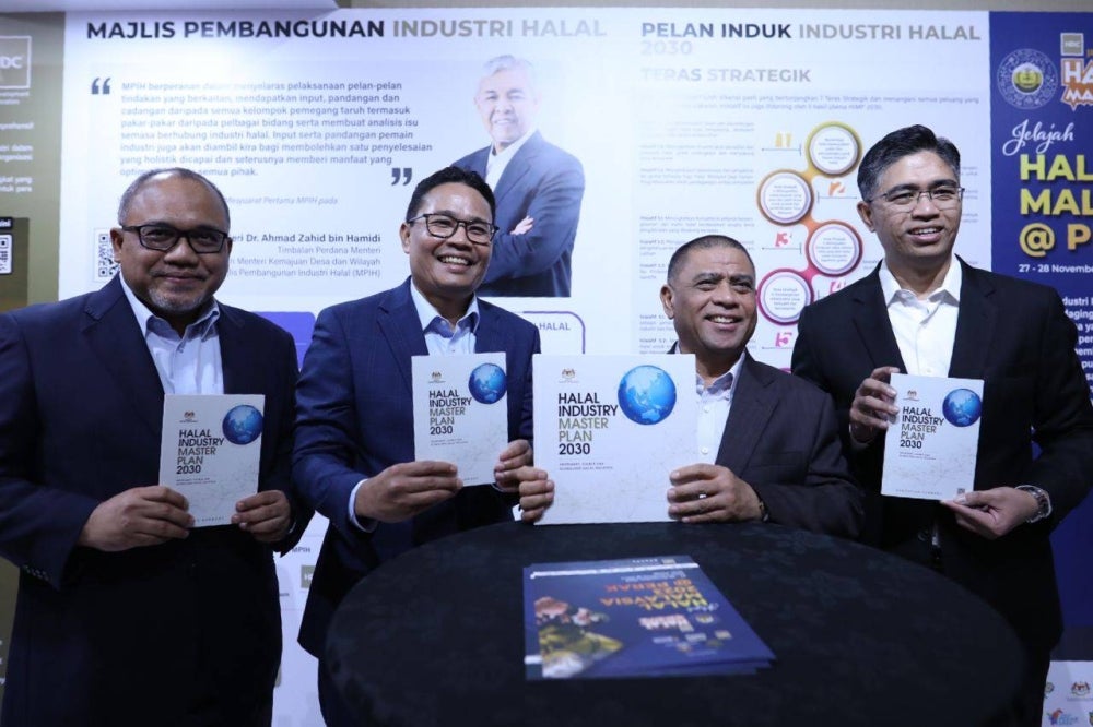 Khairul Azwan (dua dari kiri) dan Saarani (dua dari kanan) menunjukkan buku Pelan Induk Industri Halal 2030 sempena Majlis Perasmian Jelajah Halal Malaysia 2023 di sebuah hotel di sini pada Isnin. - Foto Pejabat MB Perak