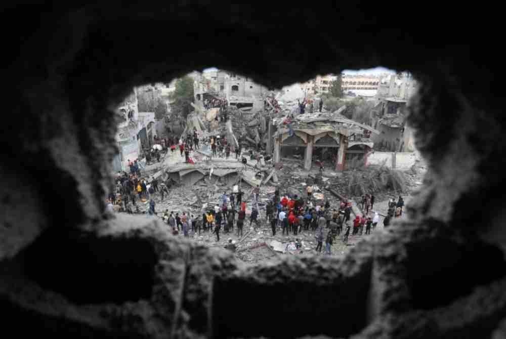 Orang ramai menjalankan kerja menyelamat di antara runtuhan bangunan yang musnah dalam serangan udara Israel di bandar Rafah, selatan Semenanjung Gaza. - Foto Xinhua