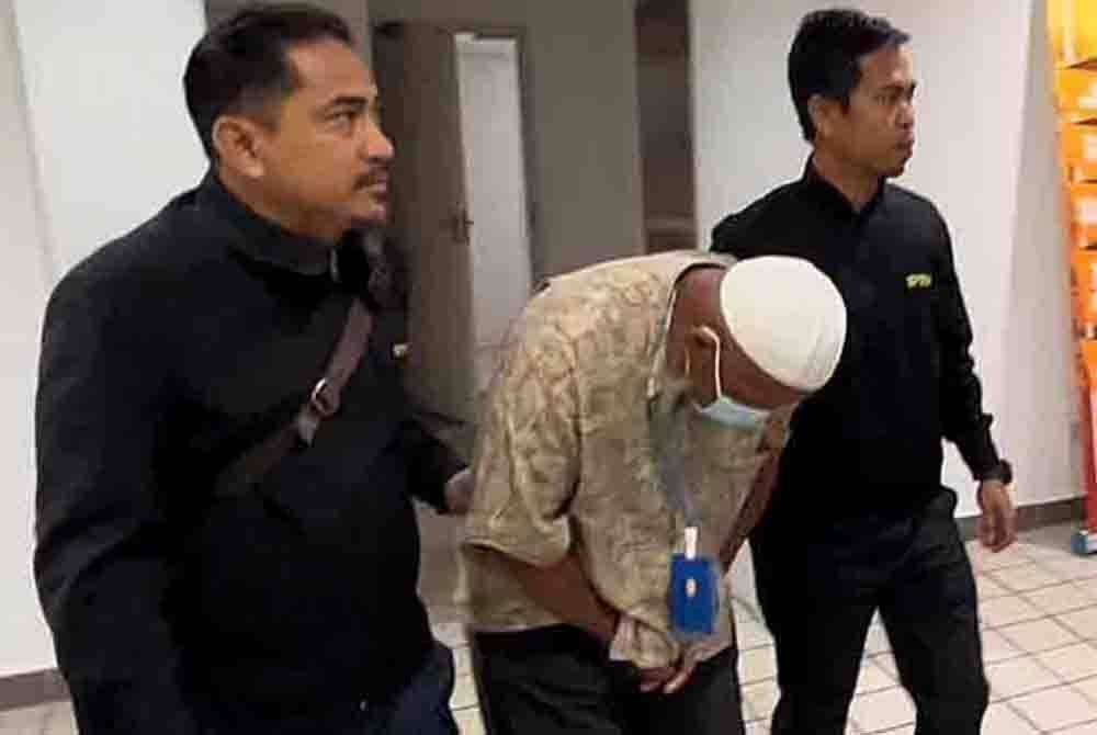 Tertuduh (tengah) dihadapkan ke Mahkamah Sesyen di Kuala Terengganu pada Selasa atas dakwaan mengemukakan borang bantuan banjir mengandungi maklumat palsu.