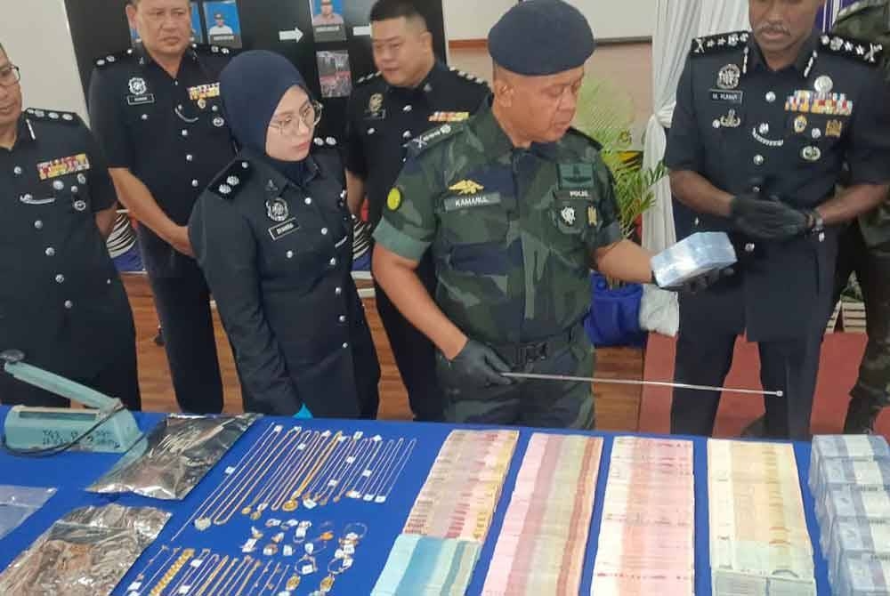 Kamarul Zaman menunjukkan wang dan dadah yang dirampas dalam serbuan di sebuah kilang, selepas sidang akhbar di IPD Seri Alam, Pasir Gudang pada Rabu