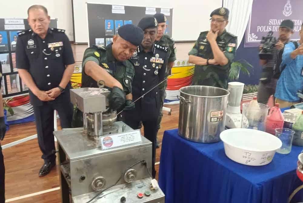 Kamarul Zaman menunjukkan satu peralatan memproses dadah yang dirampas dalam serbuan di sebuah kawasan perindustrian di Taman Pasir Puteh, Pasir Gudang pada Isnin