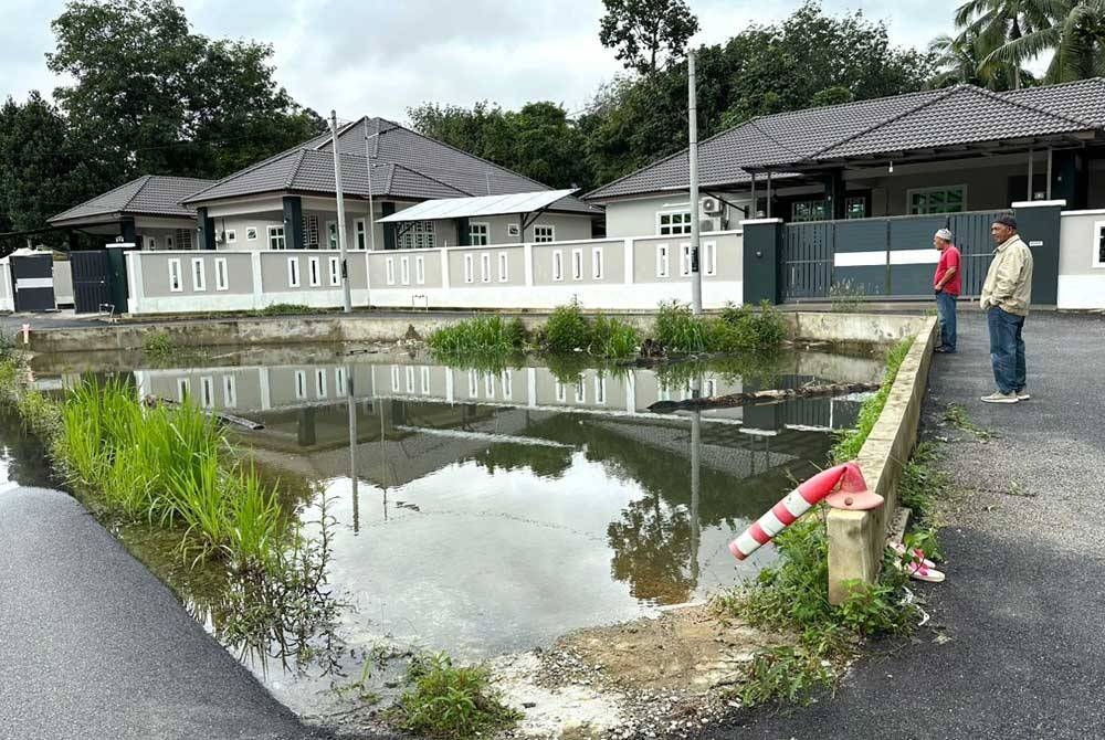 Penduduk melihat kawasan takungan air yang mengorbankan Mohamad Riskie Asraf.