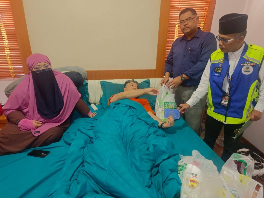 Mohd Nasir (kanan) dan Mas Imran menyampaikan sumbangan kepada Zek bagi meringankan beban keluarga di rumah sewanya di Taman Impian Emas, Johor Bahru pada Rabu