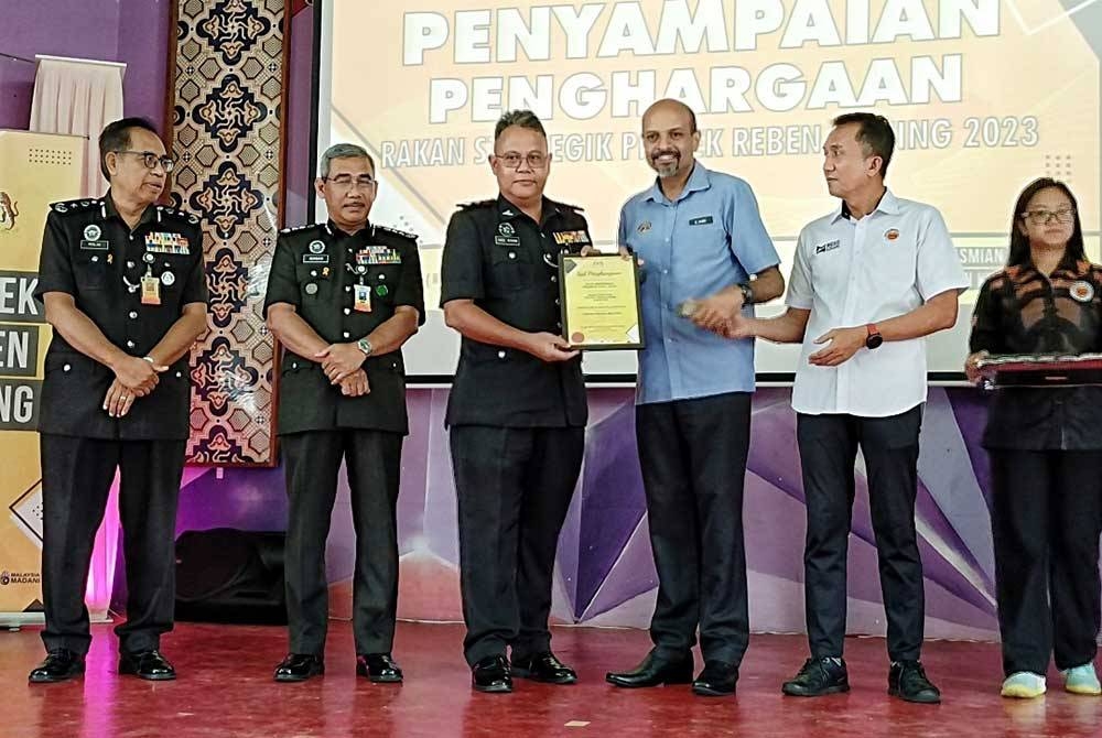 Nagulendran (empat, kanan) menyampaikan sijil penghargaan kepada wakil Sekolah Henry Gurney ketika Majlis Penutup Projek Reben Kuning 2023 di Telok Mas di sini, pada Rabu.