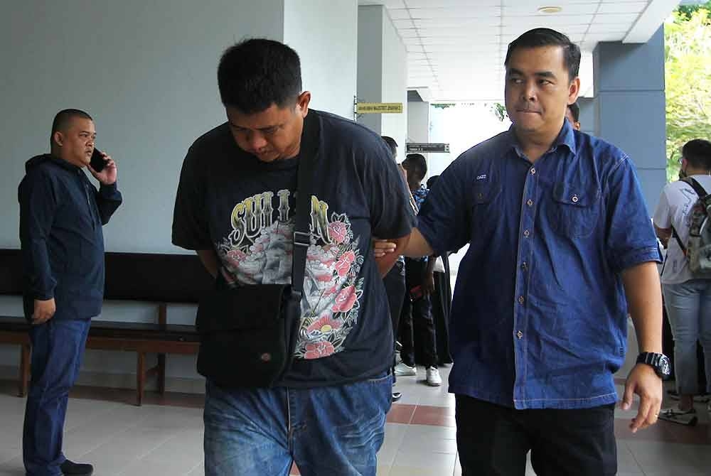 Muhammad Amsyar (kiri) diiringi polis ketika hadir di mahkamah.