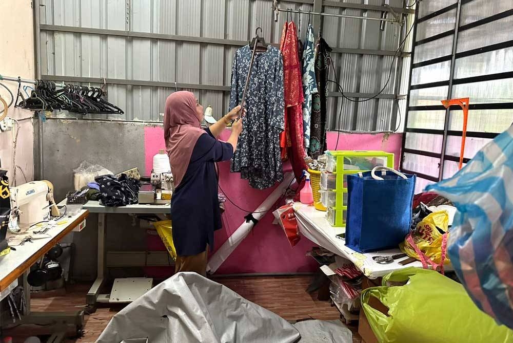 Norida terpaksa meletakkan baju-baju pelanggannya di tempat tinggi bagi mengelak daripada rosak.