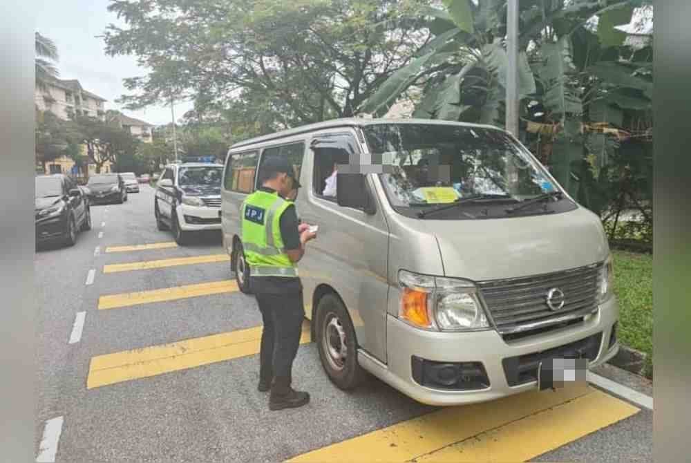 Anggota JPJ menjalankan pemeriksaan terhadap seorang pemandu van dalam Ops Bas Sekolah di sekitar Puchong dekat sini pada Rabu.