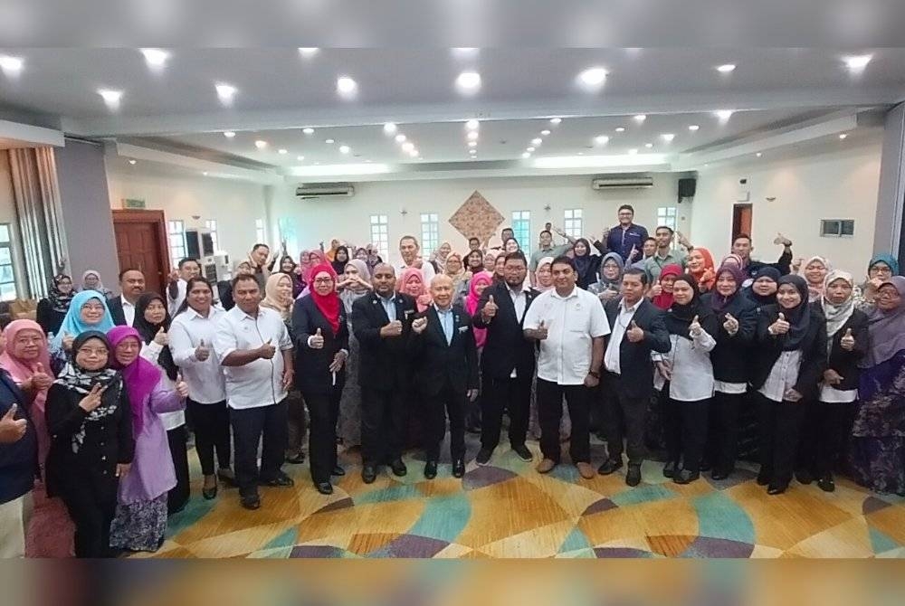 Asman ( tengah) bersama kakitangan awam pada Program Transformasi Pembantu Tadbir Cemerlang Perkhidmatan Awam Johor, di sebuah hotel di Johor Bahru pada Khamis.