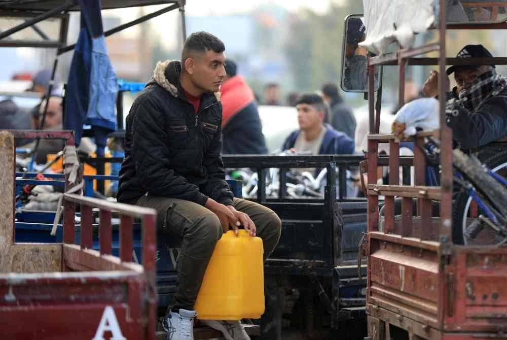 Orang ramai menunggu di stesen pengisian minyak di bandar Khan Younis, selatan Genting Gaza. - Foto Xinhua