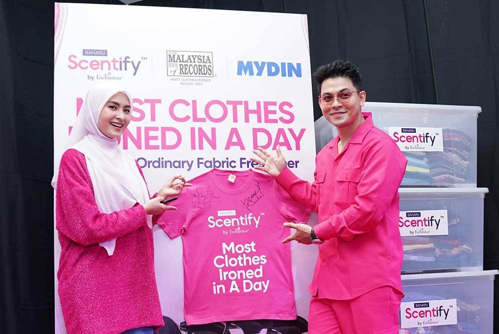 Selebriti terkenal, Wany Hasrita (kiri) dan Izzul Islam (kanan) menyertai 'duet menggosok' sempena pelancaran SCENTIFY by Enchanteur yang diadakan di Mydin USJ, pada Rabu.