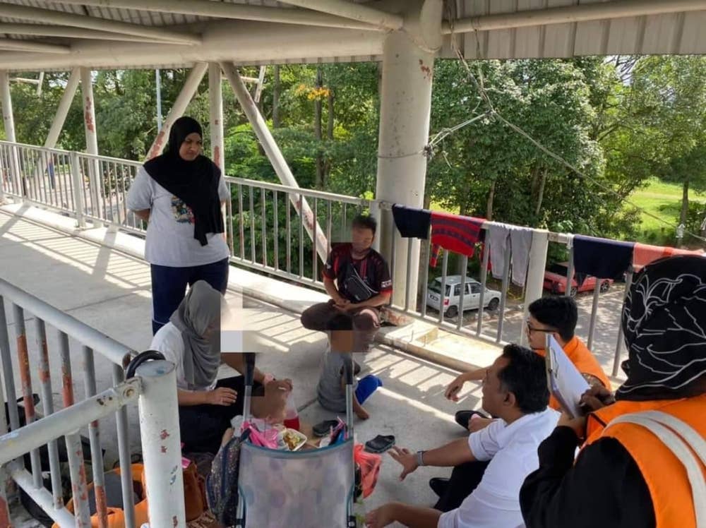 Wanita bersama dua anak yang menghuni di jejantas di Skudai di sini diselamatkan JKM pada Khamis. - Foto Facebook Marina Ibrahim 