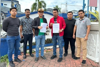 Mohamad Ezzat Zahrim (tiga dari kiri) menunjukkan laporan polis yang dibuat oleh AMK di IPD Kota Bharu, Pengkalan Chepa pada Khamis.