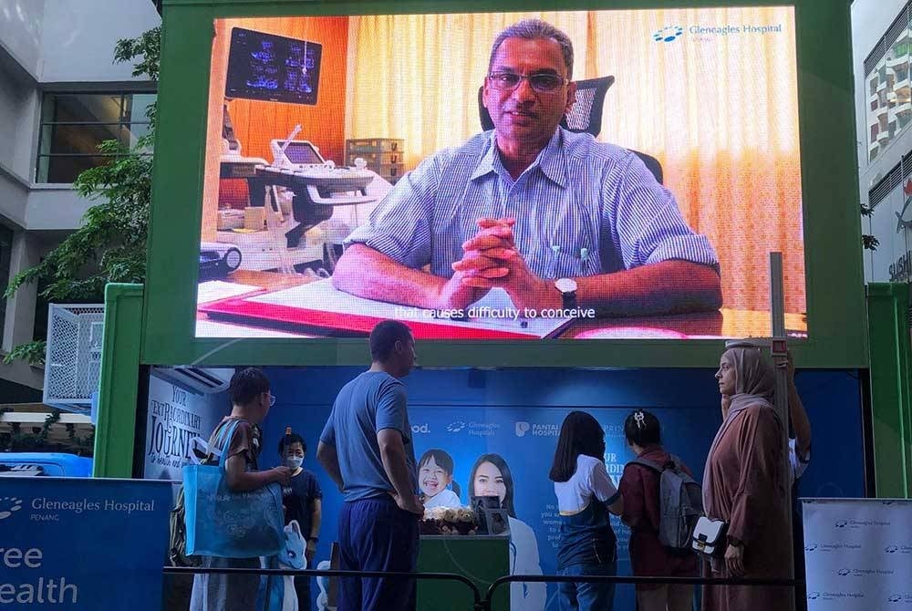 Perkongsian mengenai penjagaan kesihatan oleh pakar disiarkan melalui skrin besar pameran.