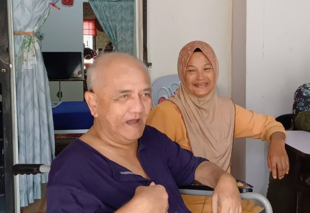 Fauziah tetap tersenyum dan setia menemani Mat Nawi yang kini tiada keupayaan bergerak di rumahnya di Taman Impian di sini 