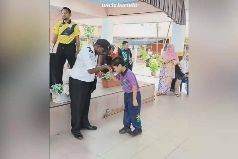 Seorang pelajar bersalam dan mencium tangan Uncle Kittu.