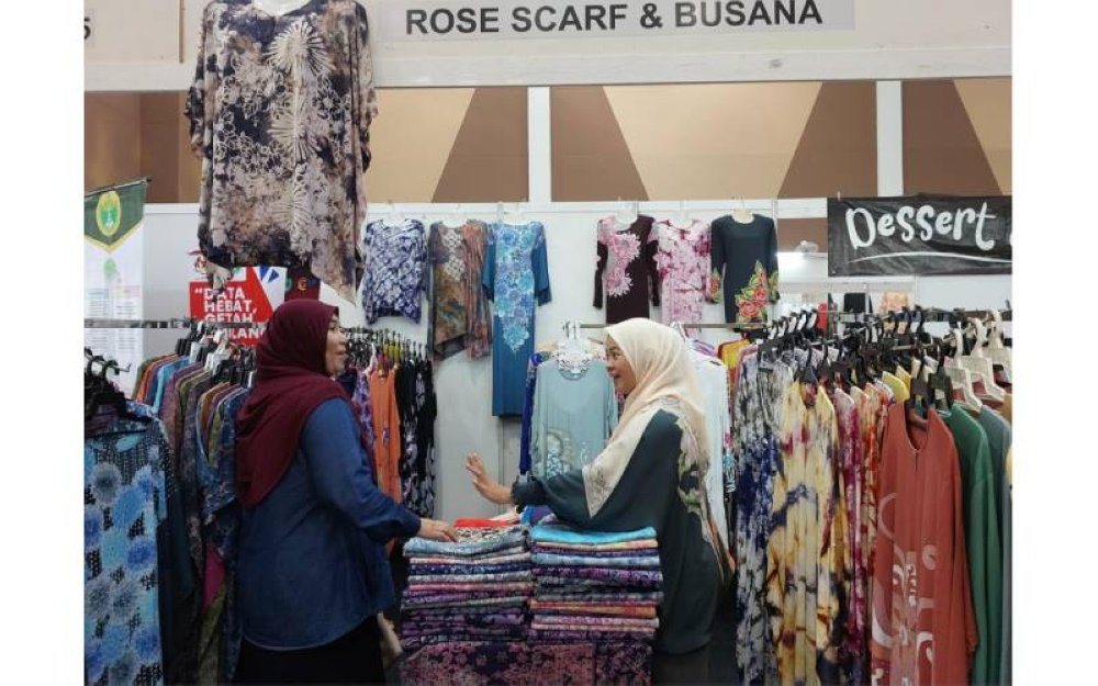 Ros Aiza (kanan) kini bangga menjadi usahawan menjual pakaian batik dan tudung yang memiliki jenama Rose Scarf & Busana hasil bimbangan daripada RISDA.