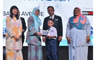 Fadhlina (dia dari kiri) menyerahkan tablet sumbangan Yayasan Didik Negara kepada seorang murid sekolah sambil disaksikan Timbalan Menteri Pendidikan, Lim Hui Ying (kiri) bersempena Majlis Peluncuran Dasar Pendidikan Digital di Pusat Konvensyen Bangi Avenue pada Selasa.