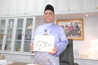 Saarani menunjukkan Buku Belanjawan Negeri Perak sebelum membentangkan Belanjawan Negeri Perak 2024 di Pejabat Menteri Besar Perak di sini pada Jumaat.