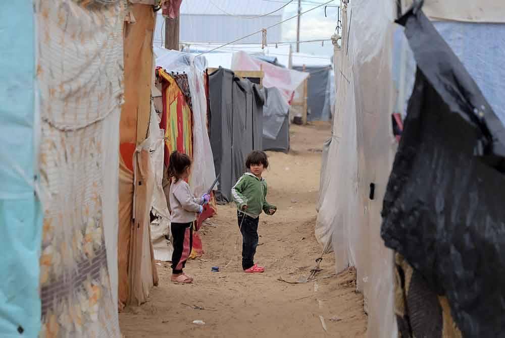 Kanak-kanak Palestin dilihat di kem pelarian sementara di bandar selatan Genting Gaza Khan Younis pada Selasa. - Foto Xinhua