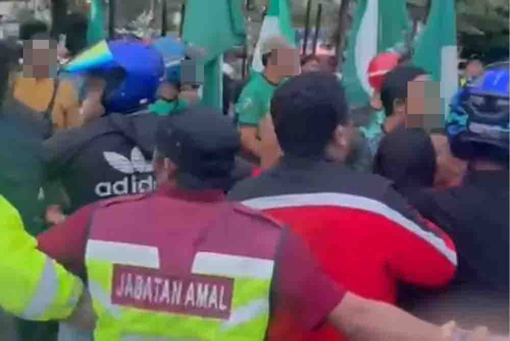 Anggota polis dan Unit Amal Pas bertindak meleraikan kekecohan yang berlaku antara penyokong Pas dan BN yang menyertai flashmob di persimpangan lampu isyarat di Jalan Sulaimani, Kemaman.