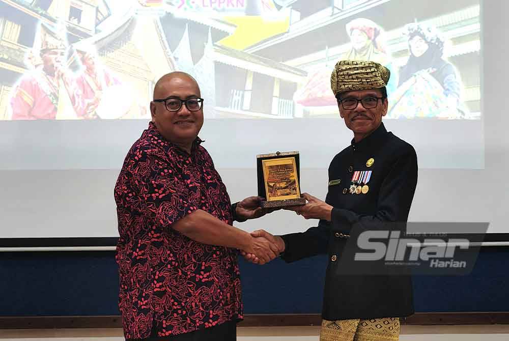 Mohd Faizal (kiri) menyerahkan cenderahti kepada Bupati 50 Kota Sumbar.