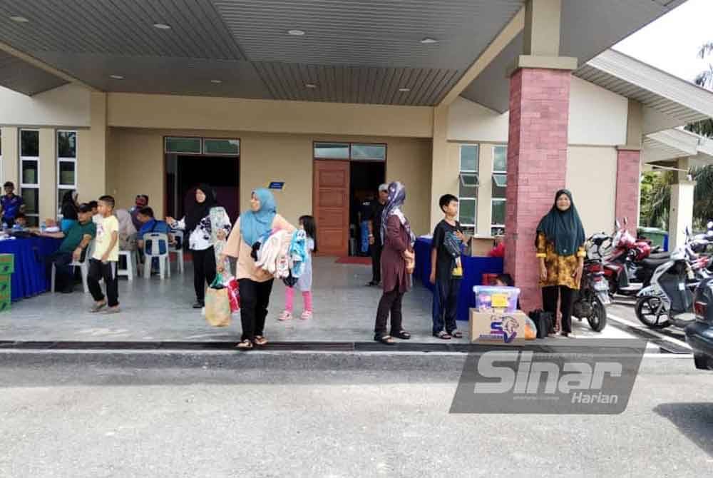 Sebahagian penduduk membawa barangan peribadi masing-masing untuk pulang ke rumah selepas PPS Dewan Muafakat Kampung Cahaya Baru ditutup tengah hari tadi.