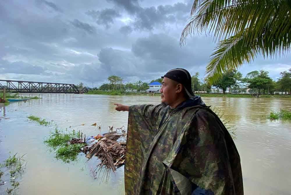 Seorang penduduk menunjukkan keadaan terkini air Sungai Golok di Rantau Panjang yang mulai melimpah pada Sabtu.