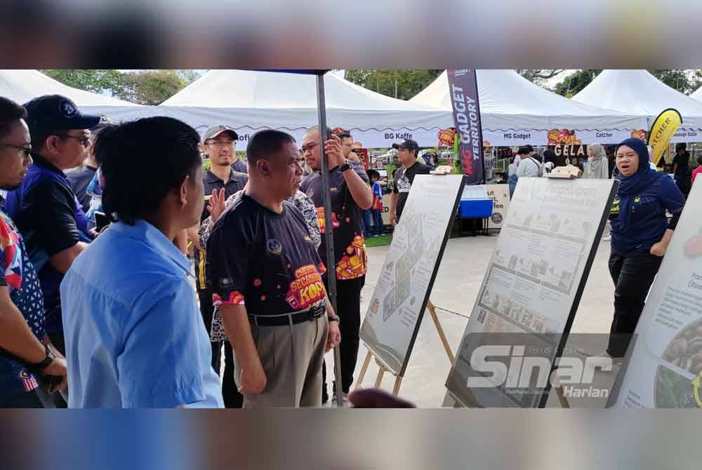 Saarani (kanan) melawat salah sebuah reruai yang disediakan pada Karnival Kopi Perak 'Cherita Secangkir Kopi' di Ipoh.
