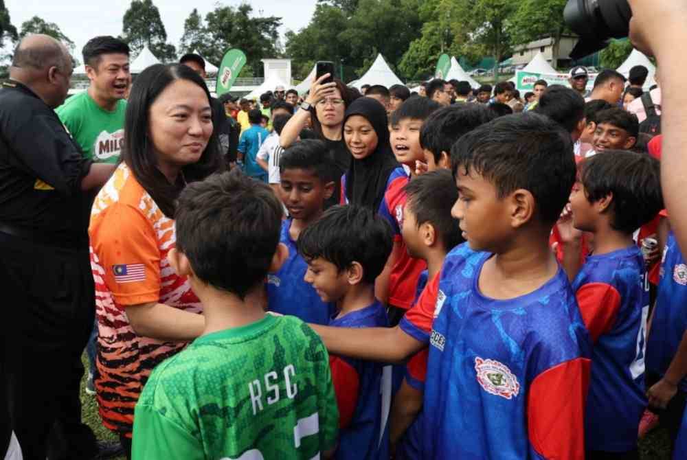 Hannah beramah mesra bersama para pemain pasukan yang menyertai Kejuaraan Bola Sepak Junior Antarabangsa Royal Selangor Club-Datuk Chu Ah Nge.