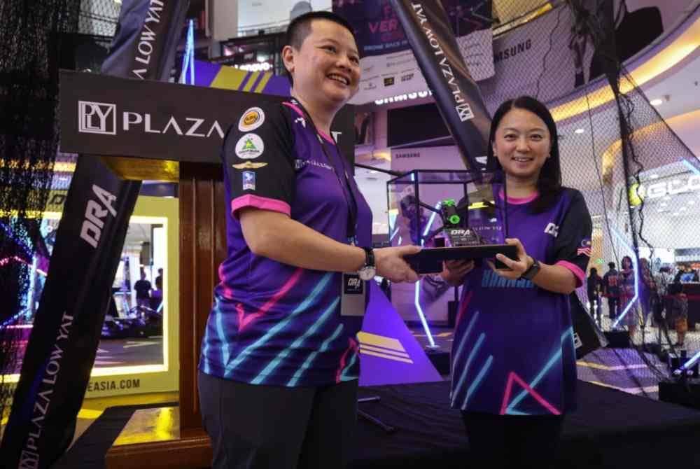 Hannah (kanan) menerima token penghargaan daripada Pengarah Magic Beans Alchemy Sdn Bhd, Y Y Choy ketika melancarkan perlumbaan DRA 2023.