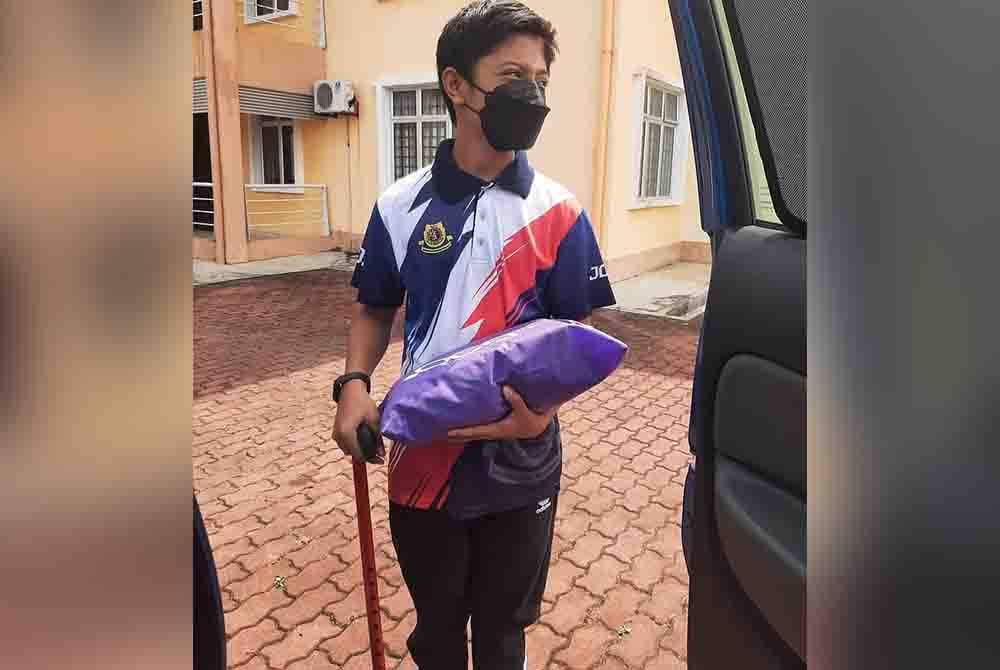 Irfan menggunakan tongkat untuk berjalan susulan penyakit Myokimia. - Foto Facebook