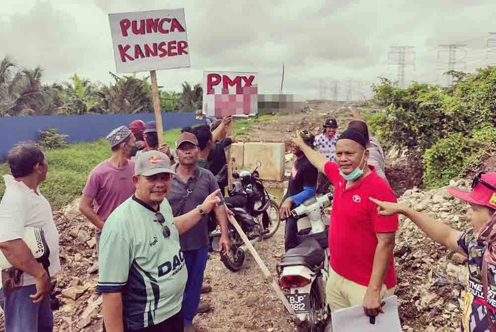 Rahim (kanan) menunjukkan tapak pelupusan sampah berkenaan.