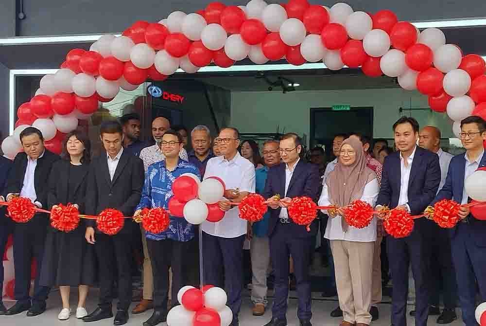 Wan Rosdy (lima dari kanan) menyempurnakan upacara memotong reben sebagai gimik pelancaran pusat khidmat 4S Chery Malaysia di Kawasan Perindustrian Semambu, Kuantan pada Ahad.