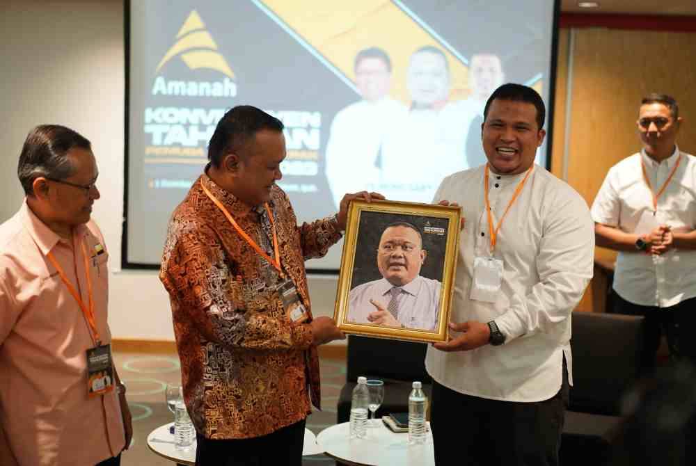 Khairol Najib (kanan) menyampaikan cenderahati kepada Mohd Sany selepas Majlis Perasmian Konvensyen Pemuda Amanah Negeri Perak di sebuah hotel di Ipoh pada Ahad.