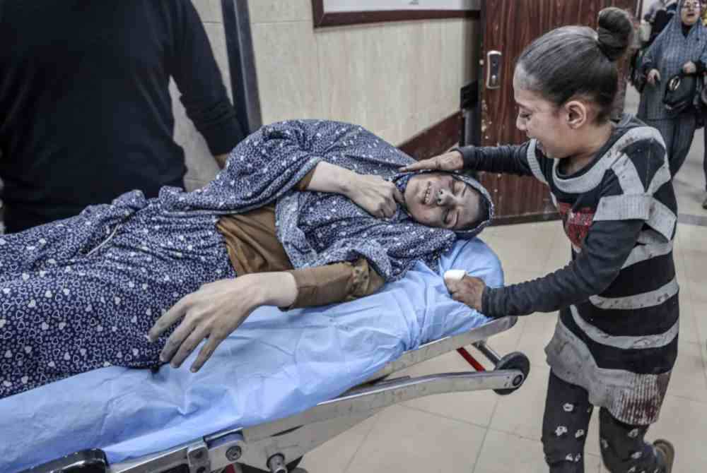 Seorang kanak-kanak menangis ketika melihat ibunya yang cedera tidak sedarkan diri diusung kakitangan perubatan.