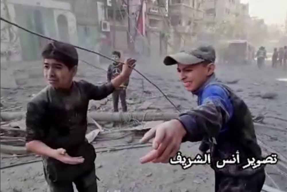 Dua kanak-kanak mencari bapa mereka yang dipercayai tertimbus di bawah runtuhan bangunan susulan serangan tentera rejim Zionis Israel di kem pelarian Jabalia. - Foto REUTERS