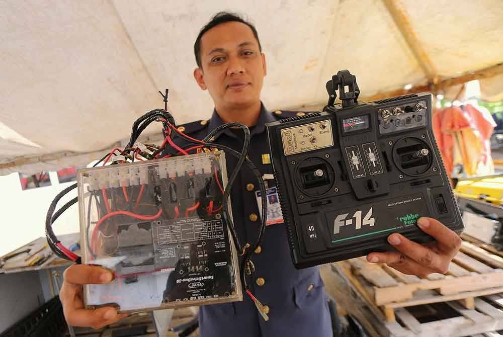 Ahmad Noor Syamsi menunjukkkan alat kawalan jauh dan 'otak' Serai Gorgon 1 (SG1) ketika ditemui di Balai Bomba dan Penyelamat Bagan Serai semalam. - Foto Bernama