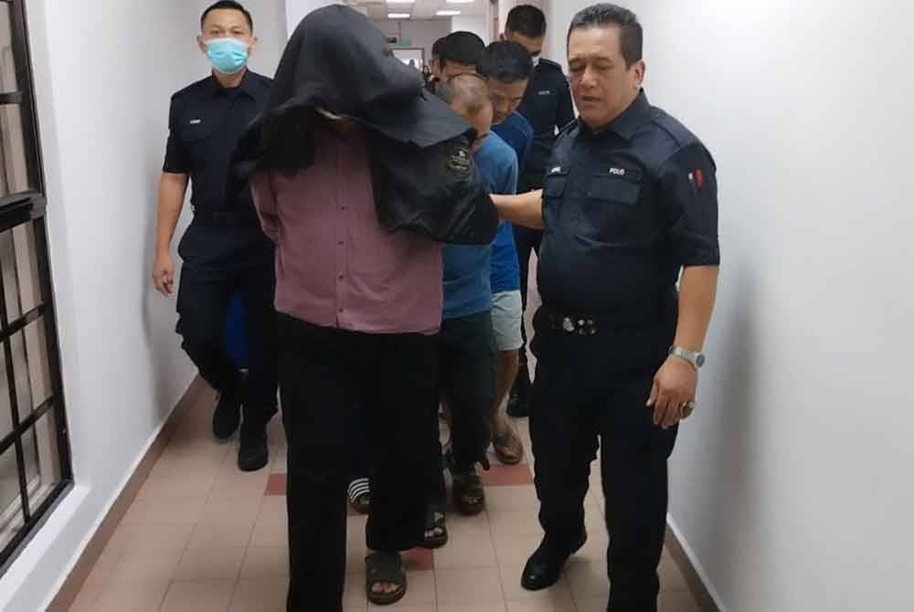Lima individu berkenaan diiringi polis di Mahkamah, pada Isnin.