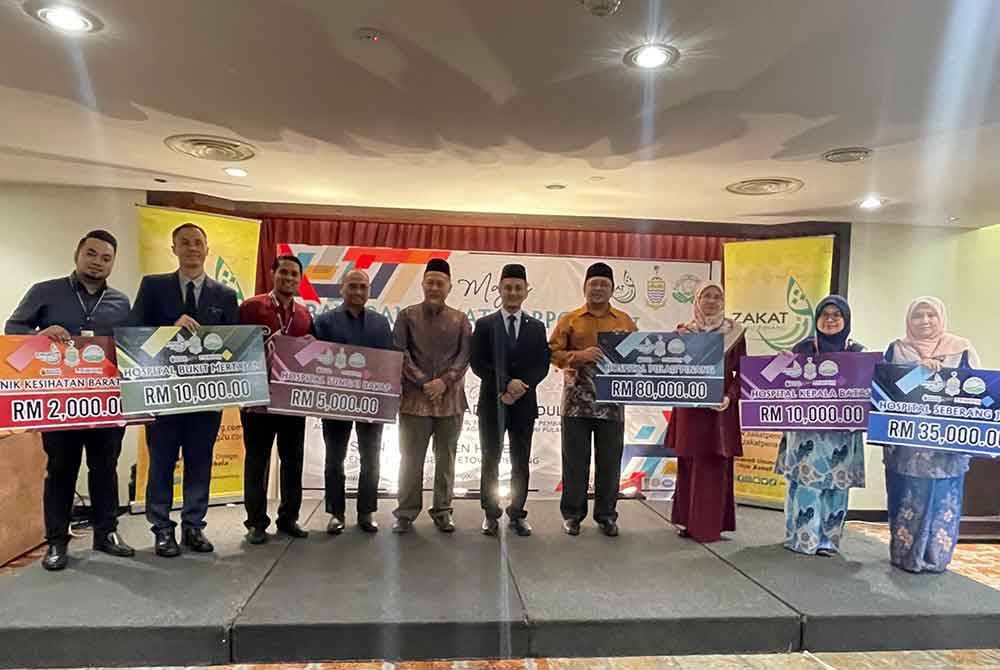 Mohamad Abdul Hamid (tengah) bersama penerima zakat korporat dalam Majlis Bayaran Zakat Korporat dan Serahan Zakat Dalam Bentuk Geran Kepada Hospital 2023 pada Isnin.