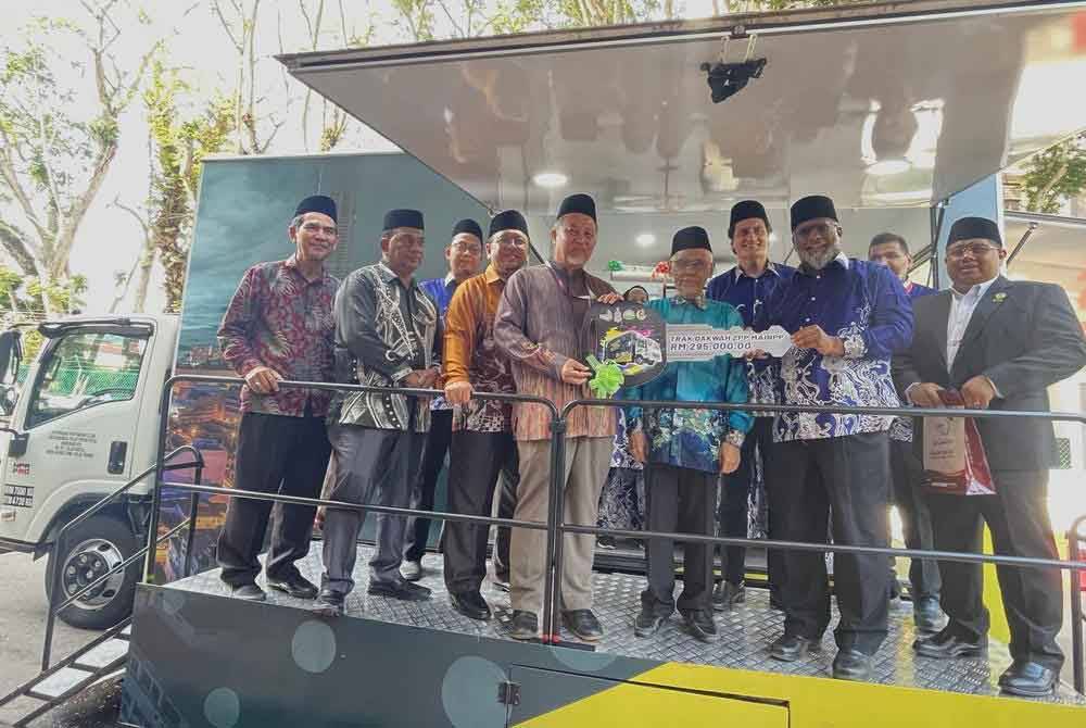 Dr Roslan (lima dari kiri) menyerahkan replika kunci kepada Kamarudin pada Majlis Penyerahan Trak Dakwah ZPP di Bangunan IPSI di George Town.