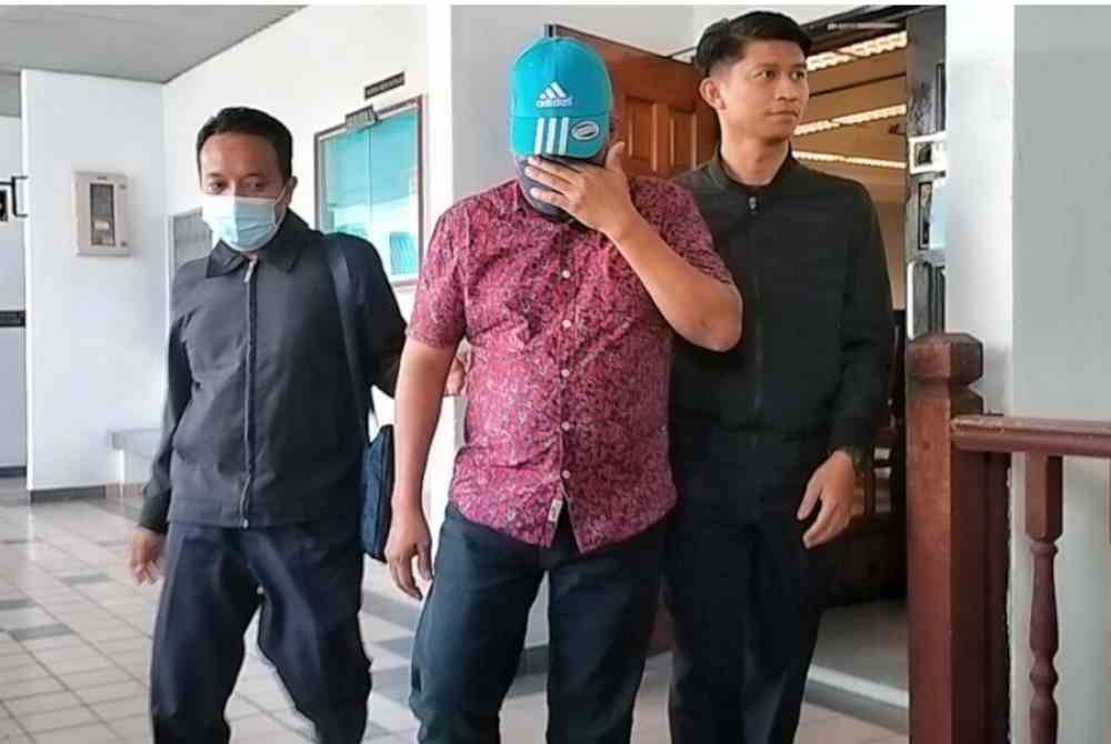 Norsham (tengah) ketika dibawa keluar dari Mahkamah Sesyen, pada Selasa.