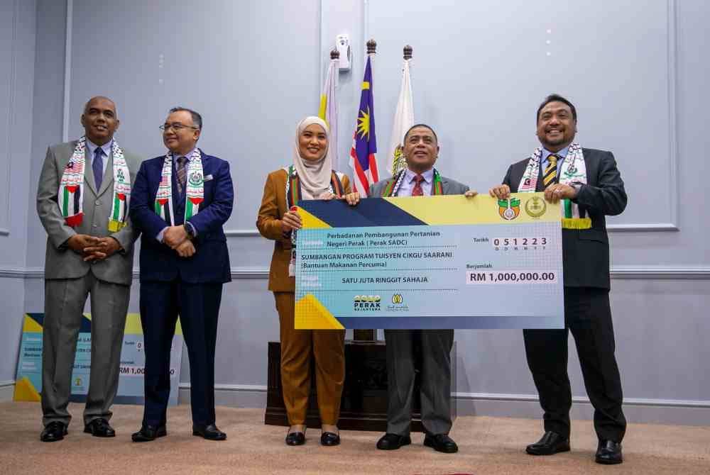 Saarani (dua dari kanan) menerima sumbangan Perak SADC untuk Bantuan Makanan Percuma ketika Majlis Penyerahan Bantuan Makanan Percuma di bawah Inisiatif Tuisyen Cikgu Saarani di Pejabat Menteri Besar Perak, di sini pada Selasa.