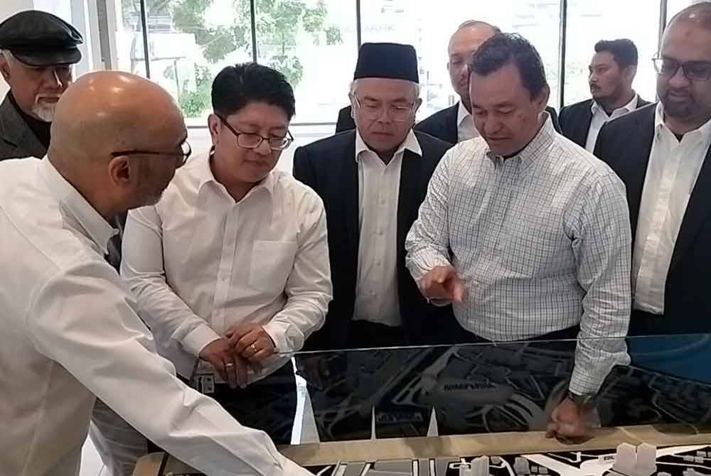 Ewon (dua dari kiri) diberi taklimat ketika melakukan lawatan kerja ke Menara Bank Rakyat di Coronation Square pada Selasa.