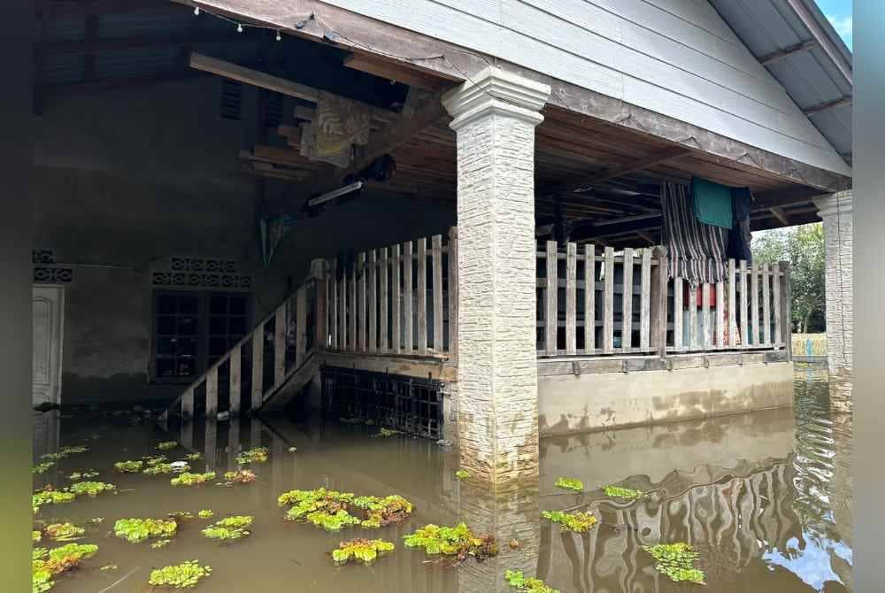 Penduduk terpaksa meletakkan barangan di atas loteng bagi mengelak ditenggelami banjir termenung.