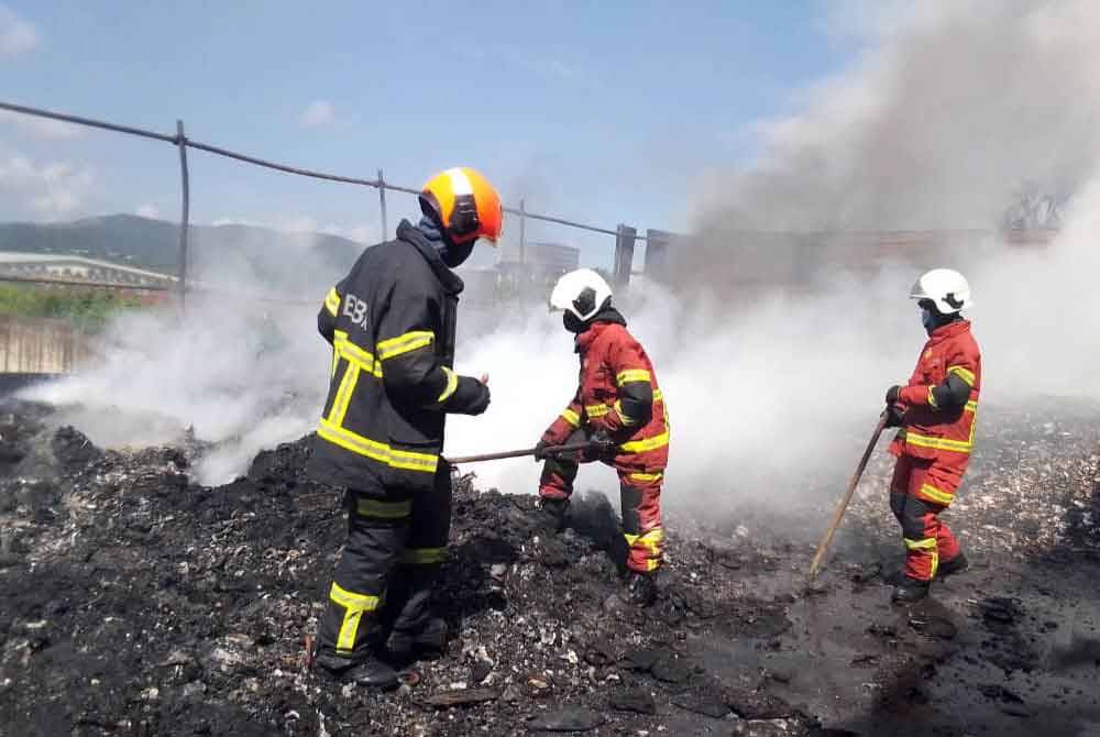 Anggota bomba memeriksa keadaan kebakaran kilang di Bukit Selambau.