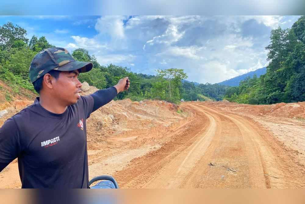 Hanif menunjukkan lokasi kemunculan harimau belang di kawasan Bukit Bakar, Machang.