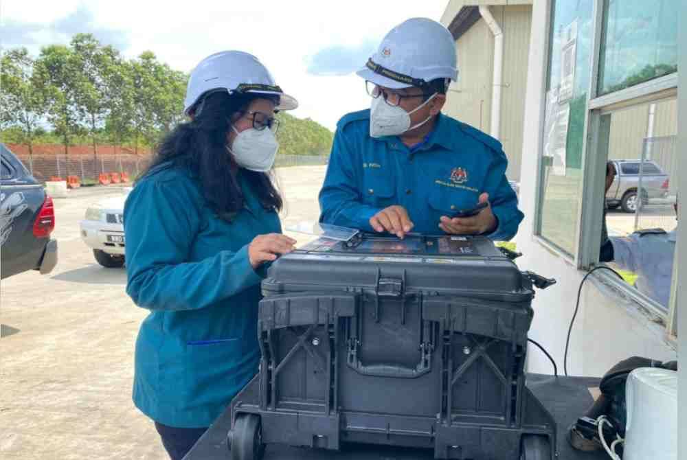 Sharifah Zakiah (kiri) memantau keadaan lokasi kebakaran di Bukit Selambau. - Foto JAS