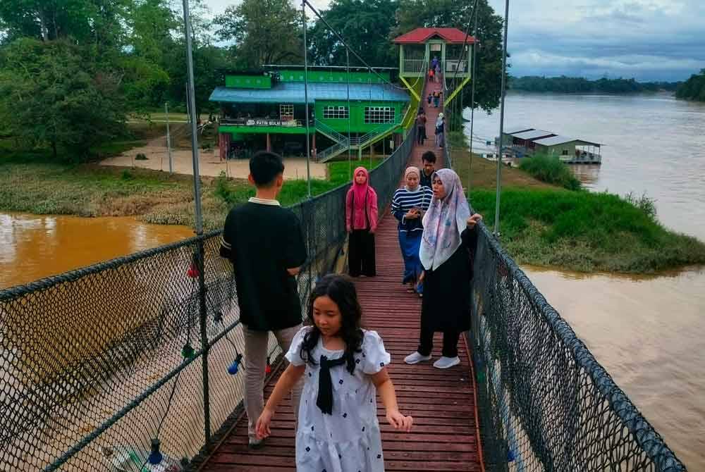 Orang ramai tidak melepaskan peluang bergambar di atas jambatan.